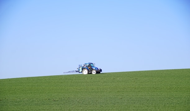 A friendly technician assisting a farmer with a tablet in a sunny field.