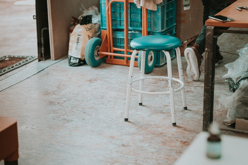 empty round green stools beside brown table