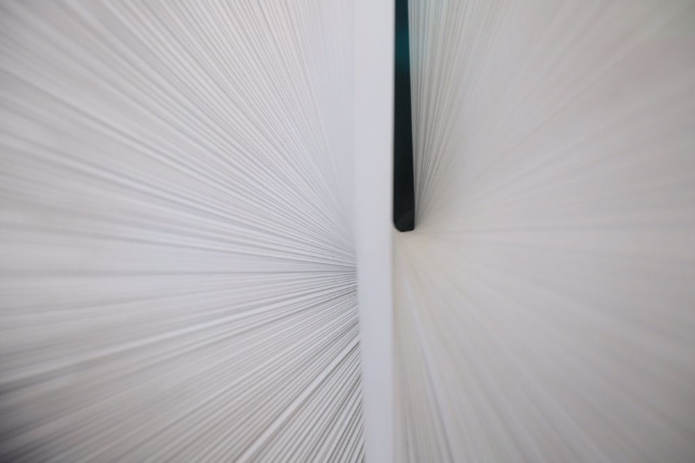 a close up of a white wall with a black pole