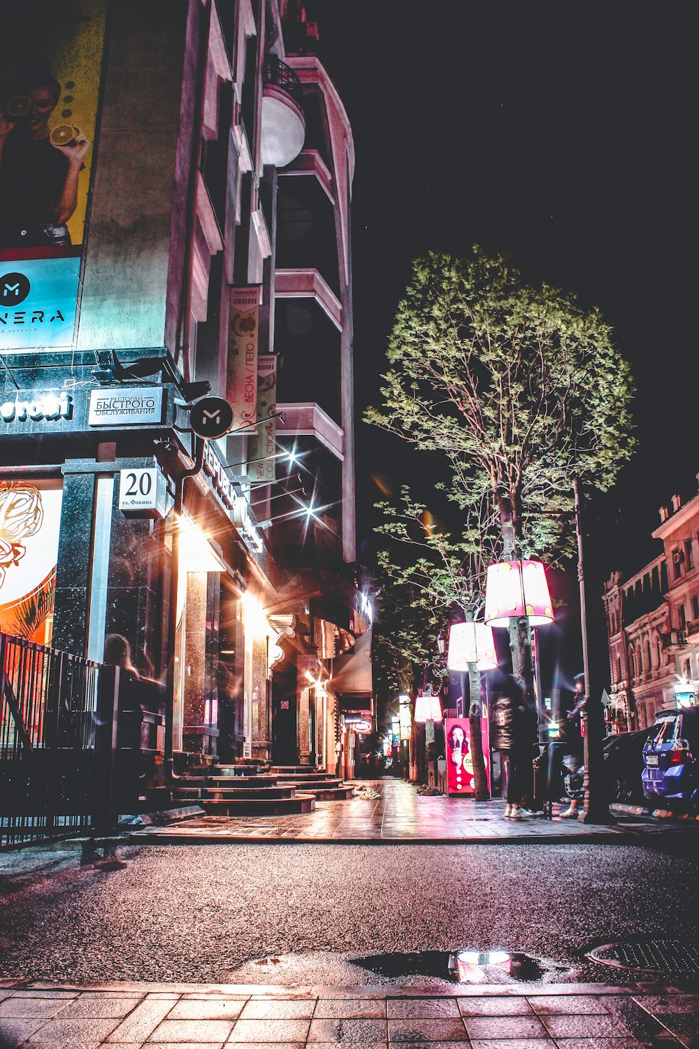 a city street at night with a clock tower in the background