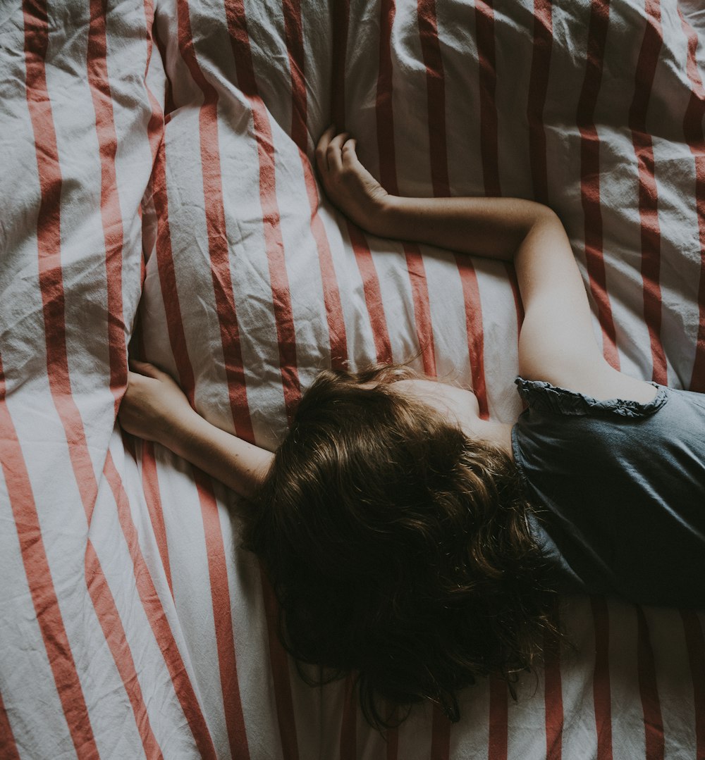 woman laying on white and red striped bedspread