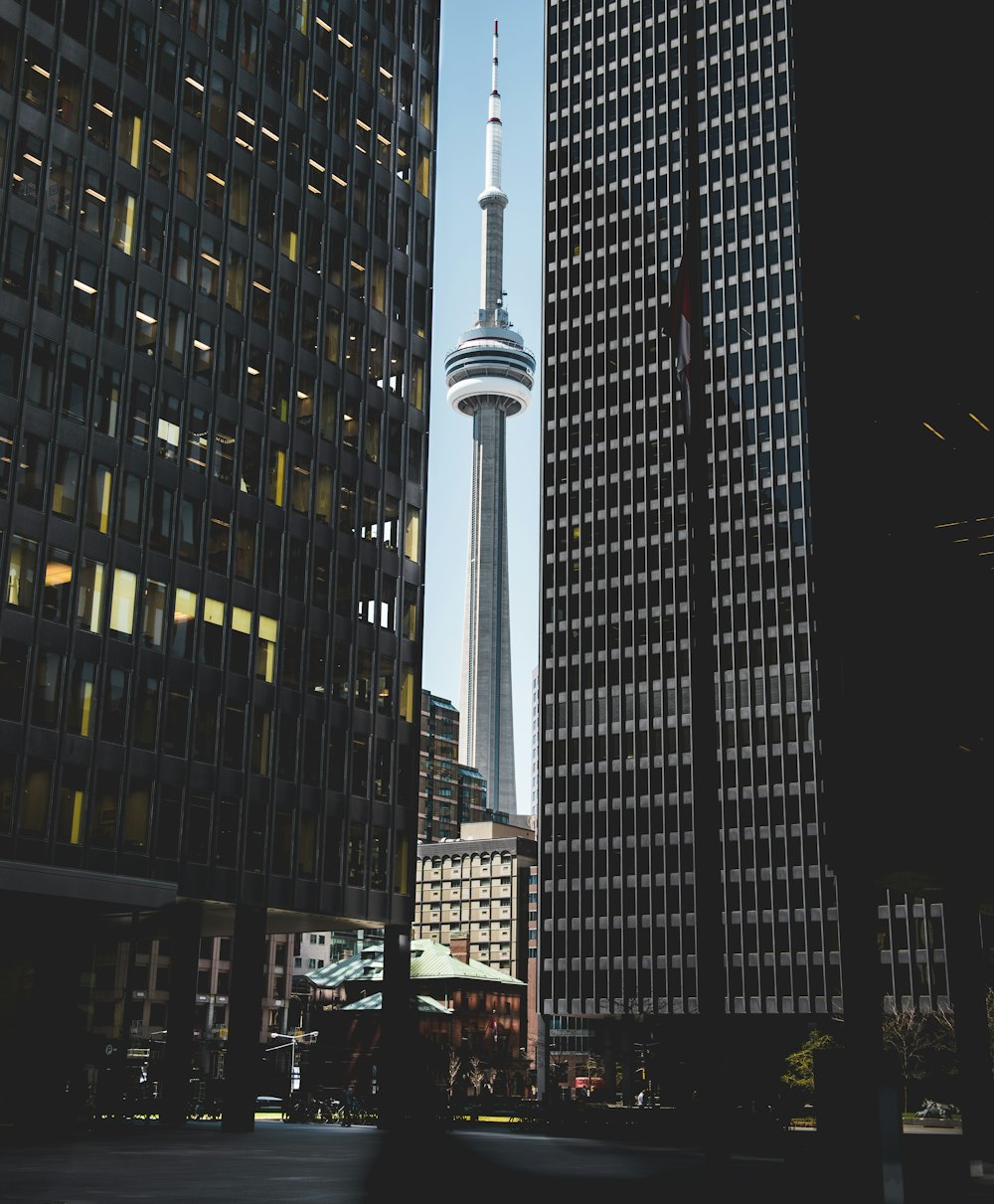 white tower building in middle of two tall buildings