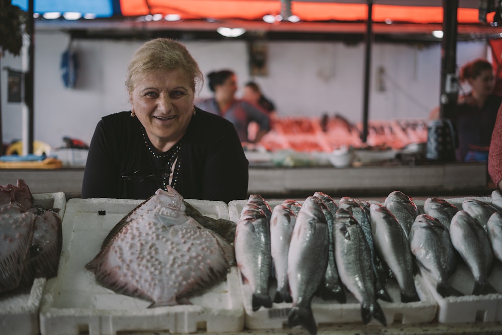 mujer de pie frente a la exhibición de peces