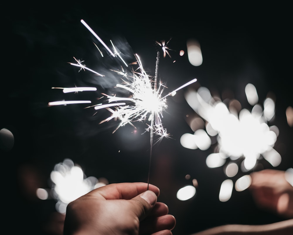 person holding sparklers photography