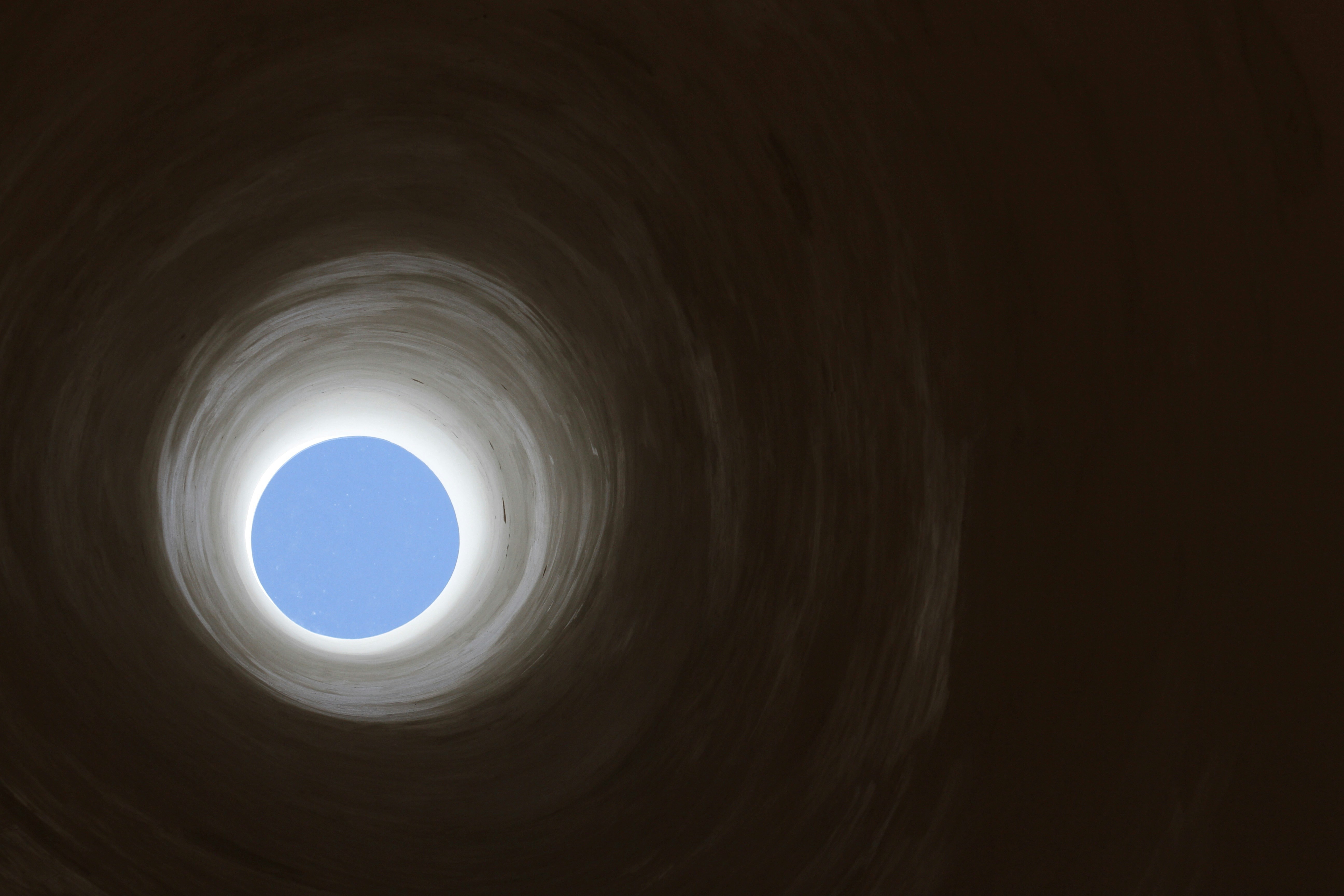 暗闇から明るい穴を見上げた様子