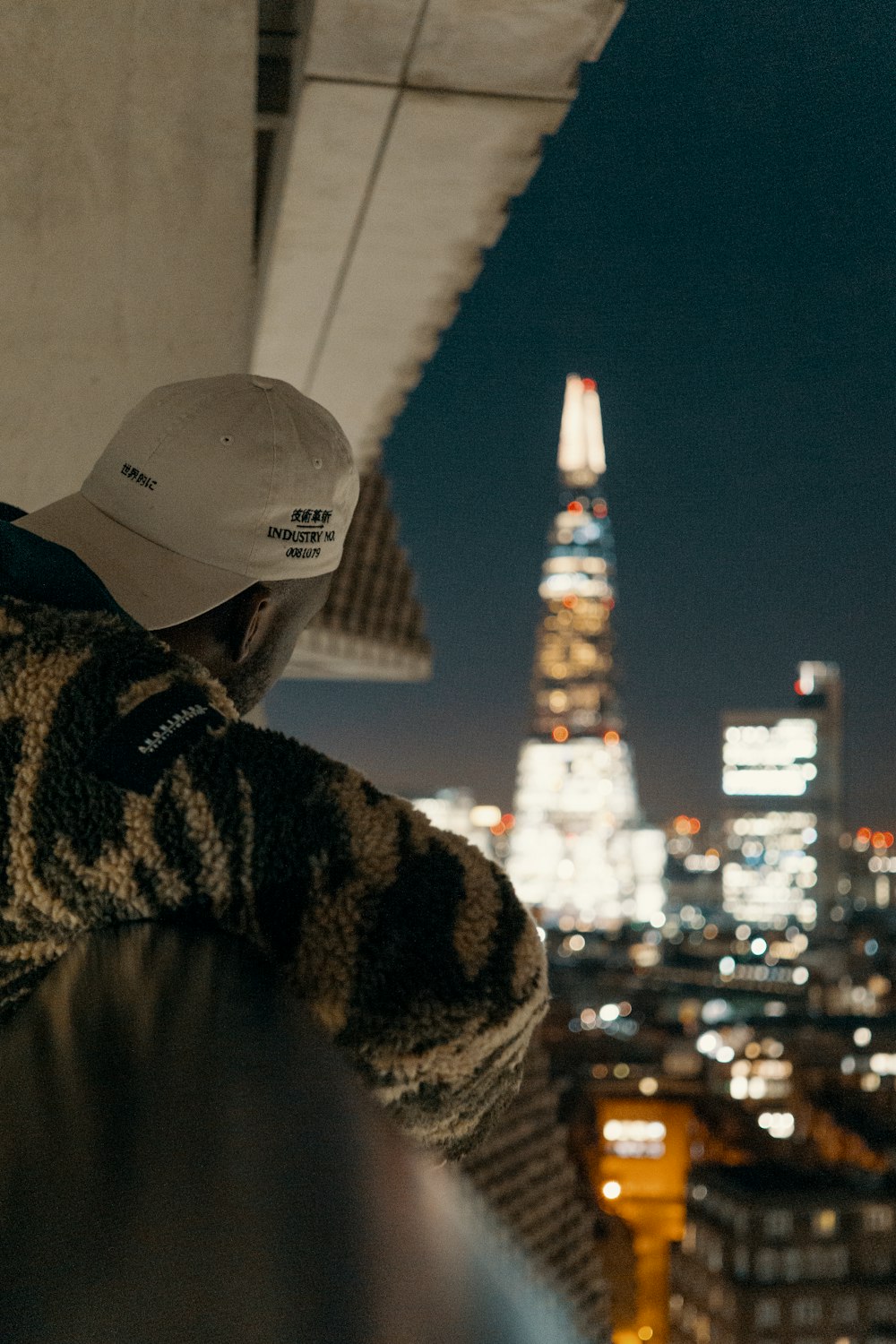 man on gray fence near tower building