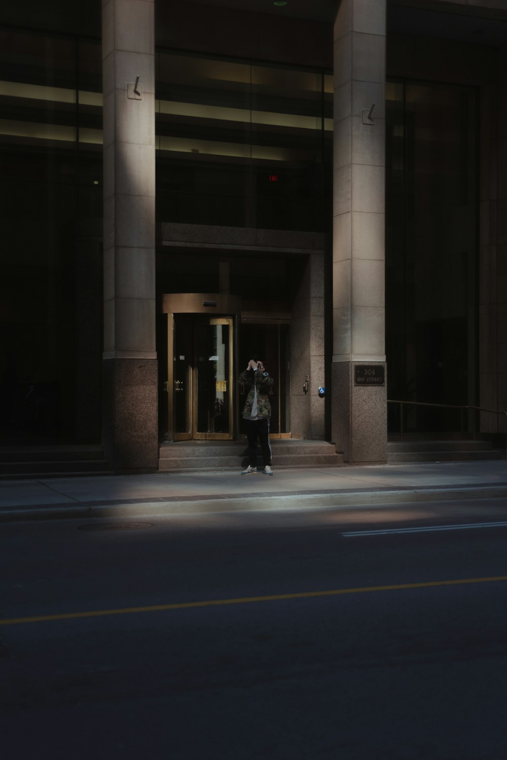 회색 콘크리트 건물 근처에 서 있는 사람