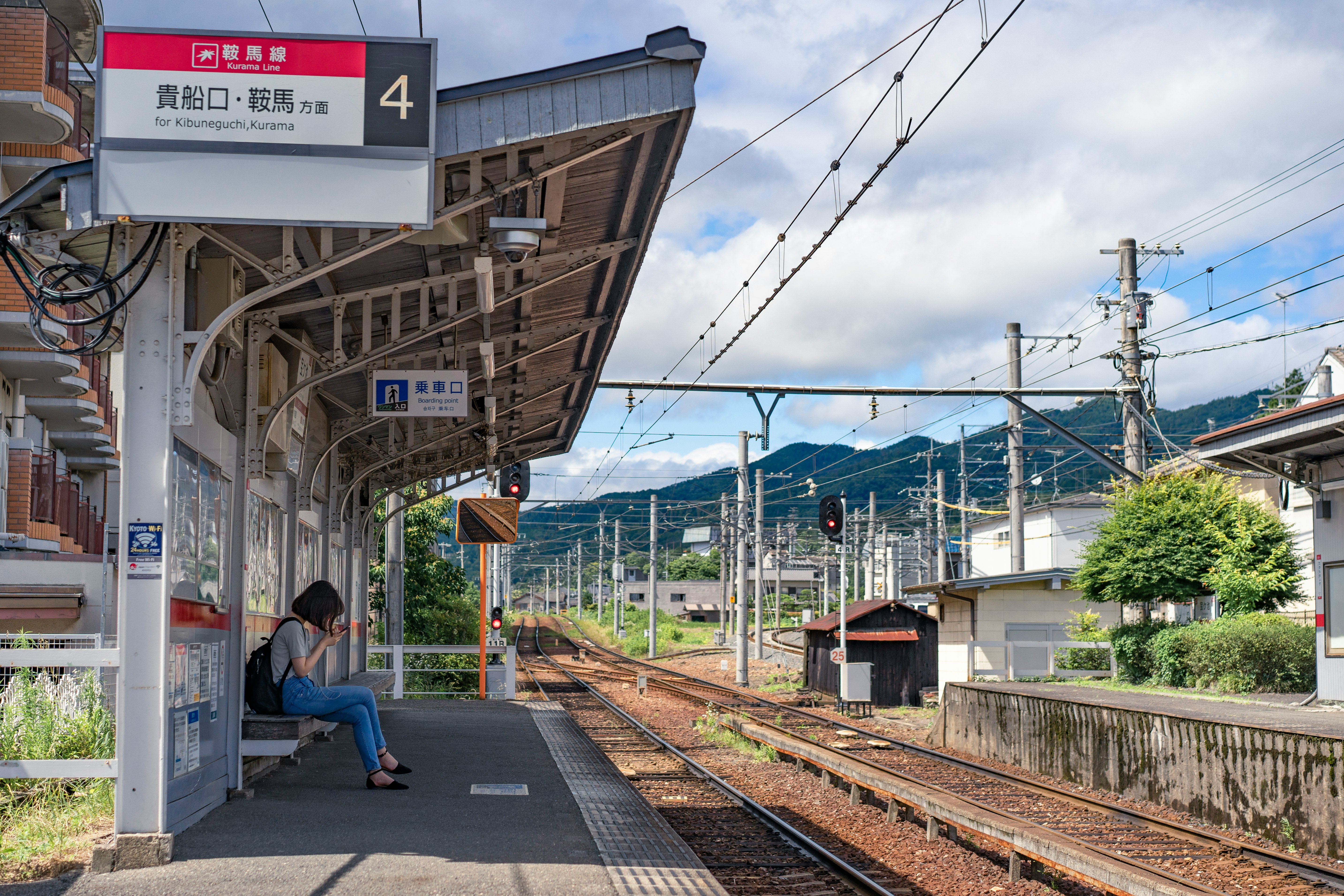 woman sitting on canopy while waiting train