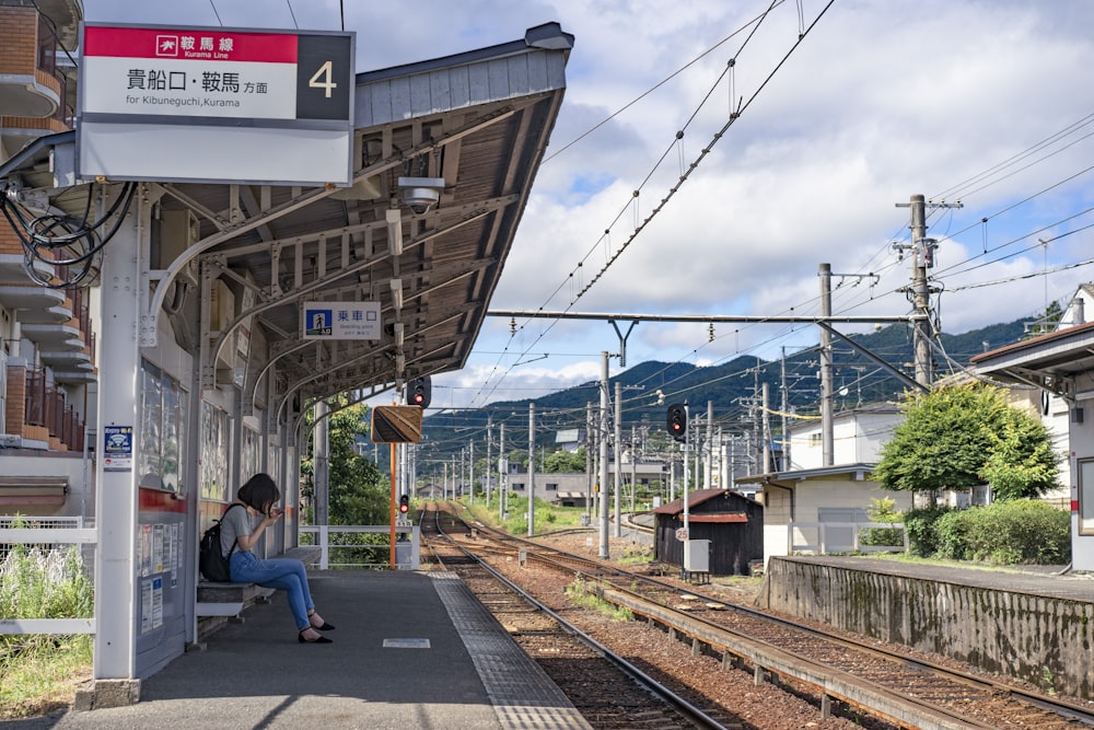 mulher sentada no dossel enquanto espera o trem