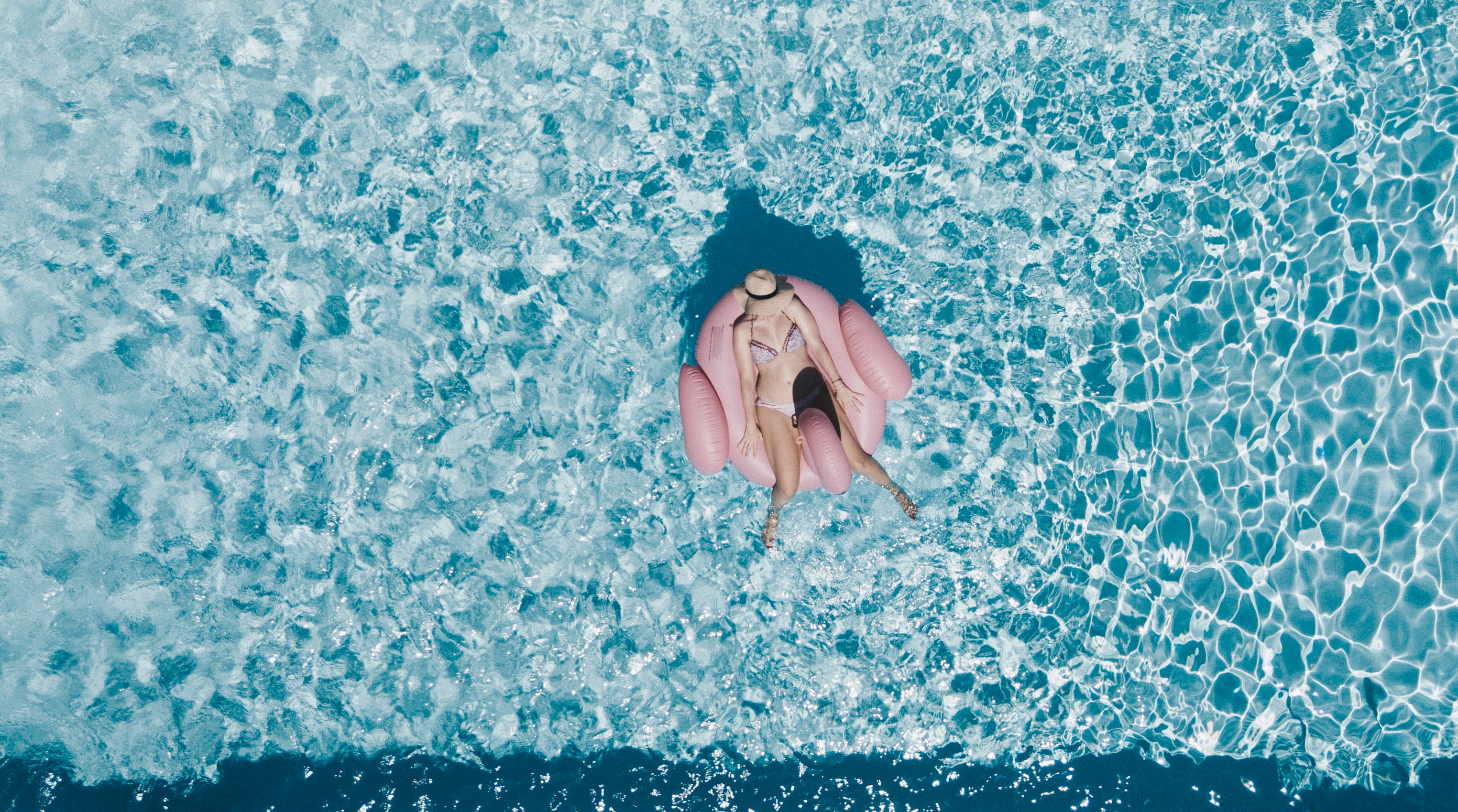 woman on pink buoy surrounded by body of water during daytime