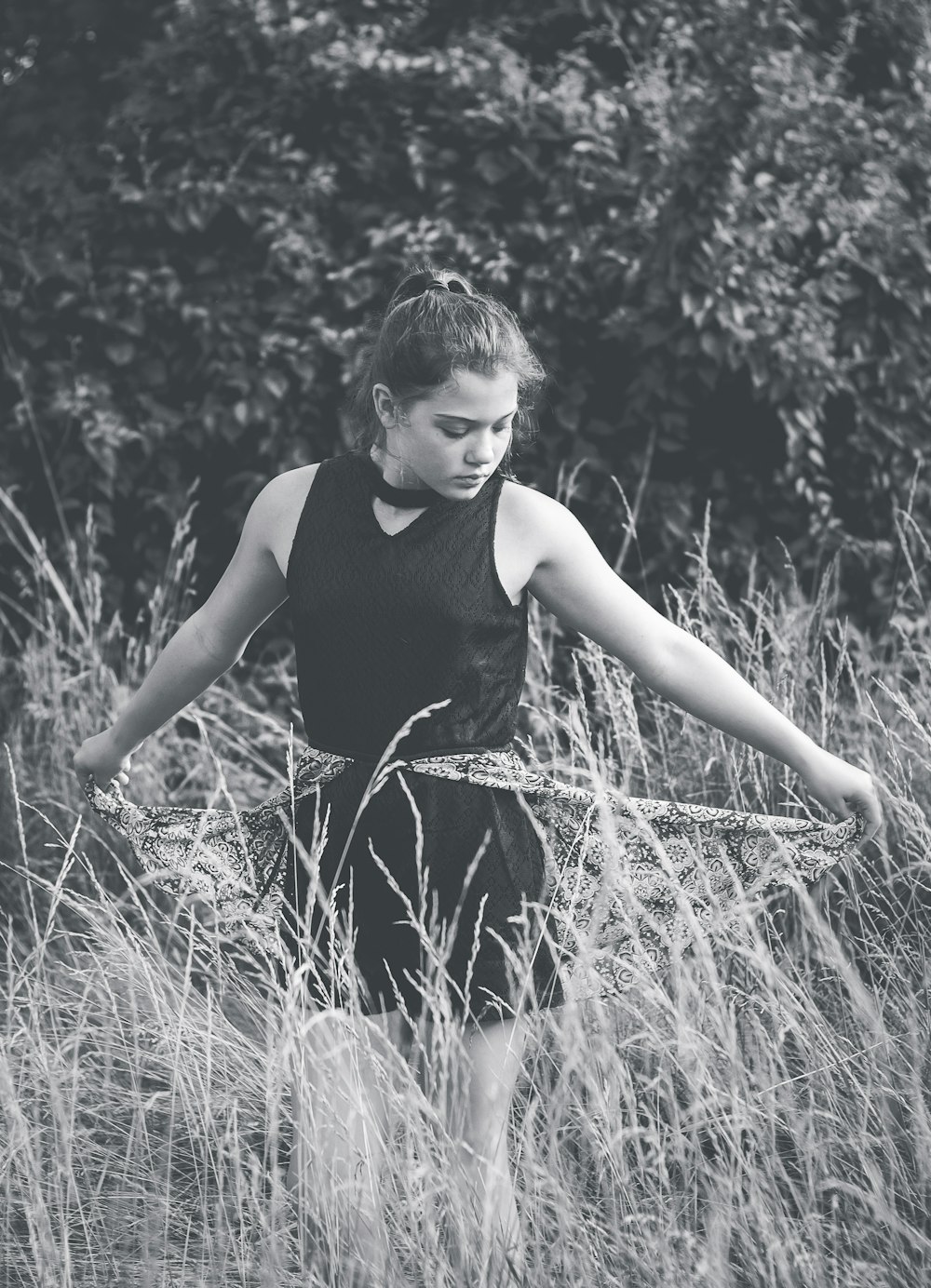 grayscale photo of woman standing on grass