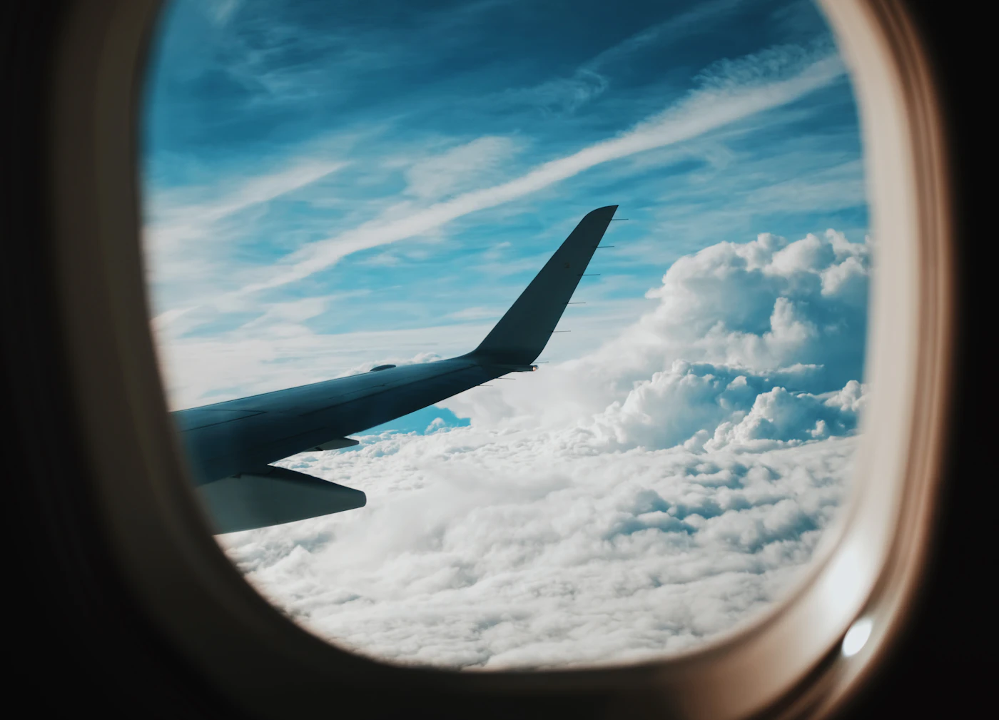 A wing above the clouds, seen from the cabin