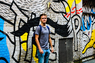 A vibrant photo of a young person wearing bold, colorful streetwear with urban graffiti in the background.