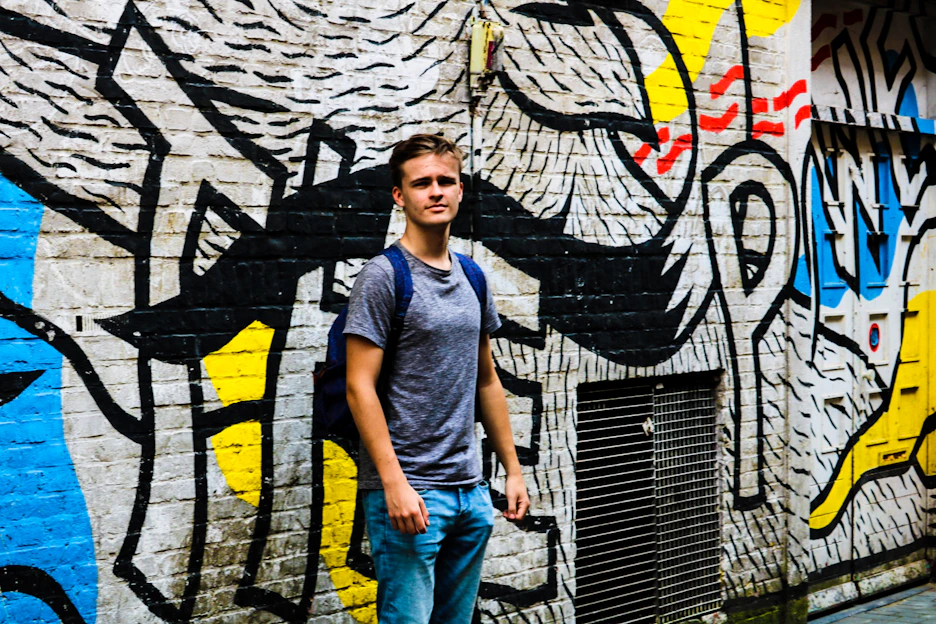 Young person wearing a colorful oversized custom t-shirt in an urban graffiti setting