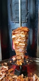 Close-up of a sizzling shawarma spit with juicy meat layers.