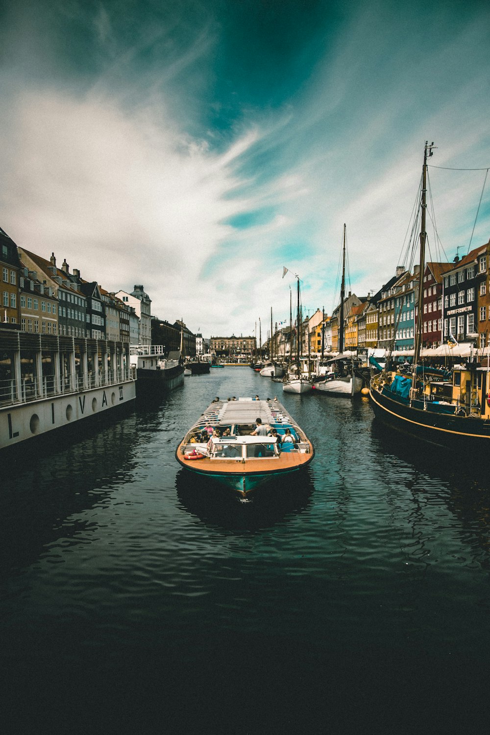 a boat floating on top of a river next to tall buildings