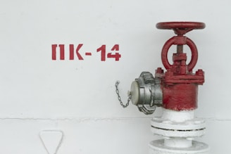 red and white fire hydrant beside white wall