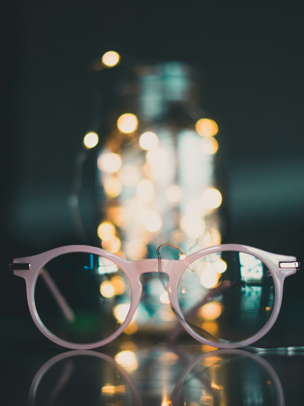 gray framed eyeglasses near glass jar