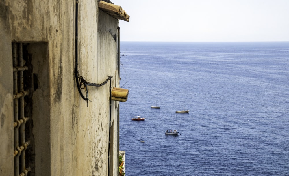 four assorted boats near concrete castle