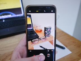 A warm, inviting desk with a smartphone, notebook, and a cup of tea symbolizing friendly customer support at uk mobile hub.