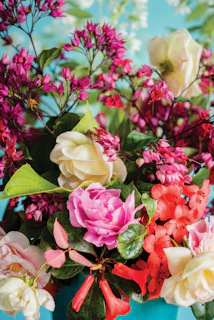 Artisan-crafted floral composition featuring wildflowers and seasonal blooms in a cream-colored vase.