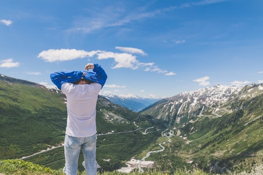 man standing in front of the mountain in Furka Pass Switzerland