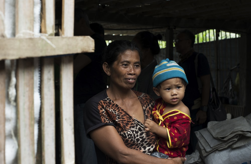 Mujer cargando a un niño cerca de la puerta