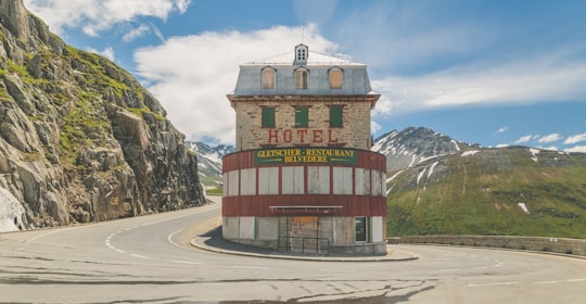 Hotel between road near green mountain at daytime in Grotte de Glace, Glacier du Rhône Switzerland