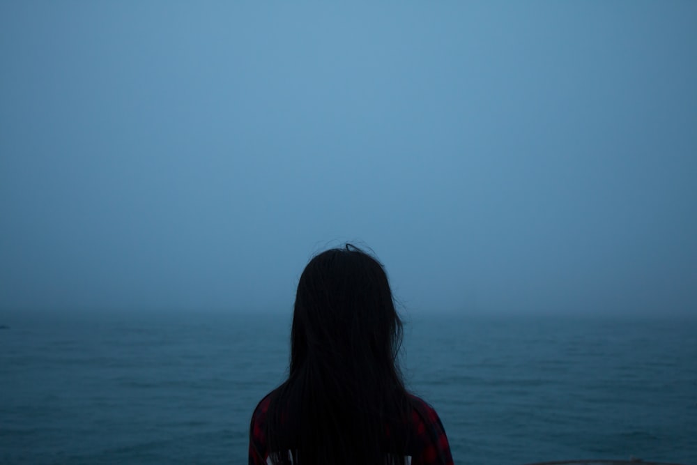 Foto di silhouette donna di fronte allo specchio d'acqua