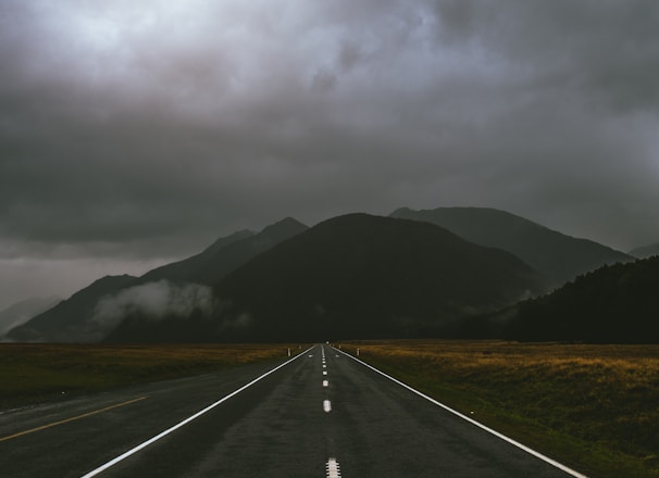 gray road under cloudy sky