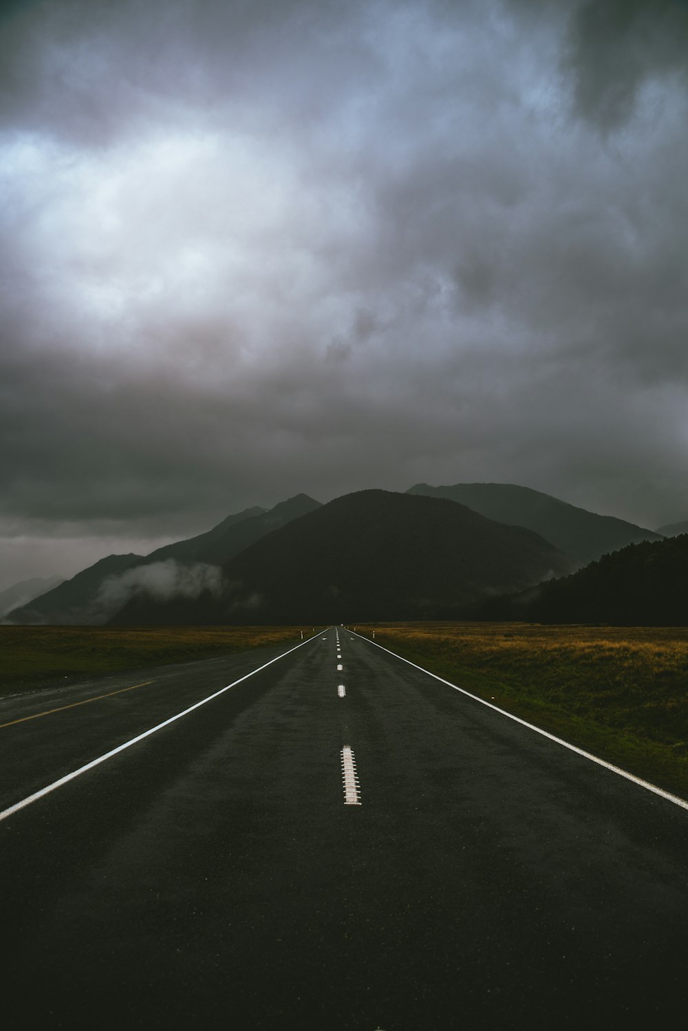 route grise sous un ciel nuageux