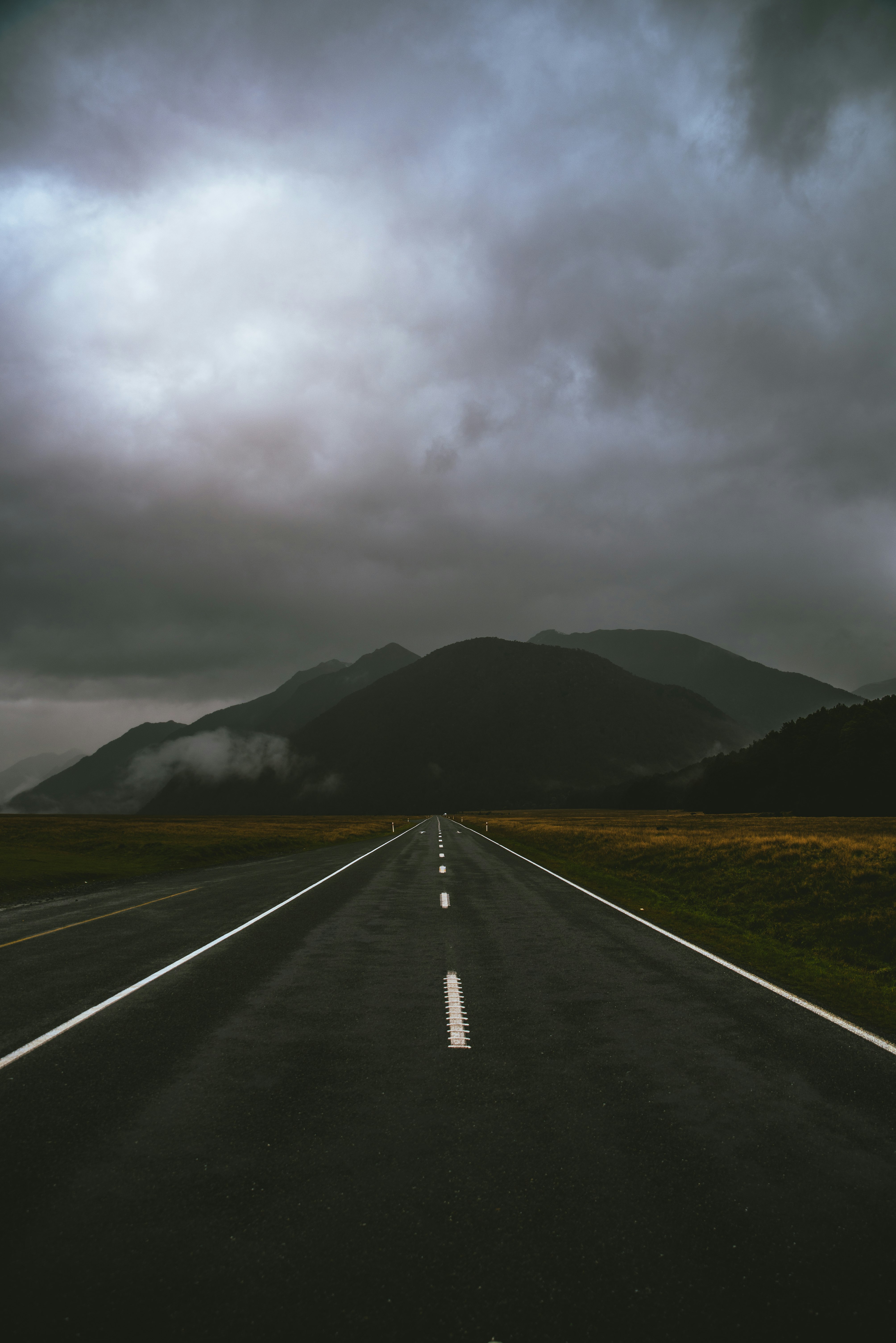 gray road under cloudy sky