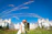 A joyful couple exchanging vows in a historic castle courtyard surrounded by lush vineyards.