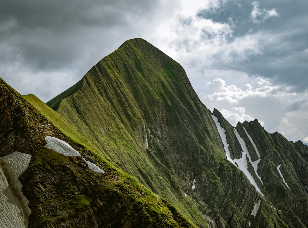 Montagna verde sotto il cielo nuvoloso