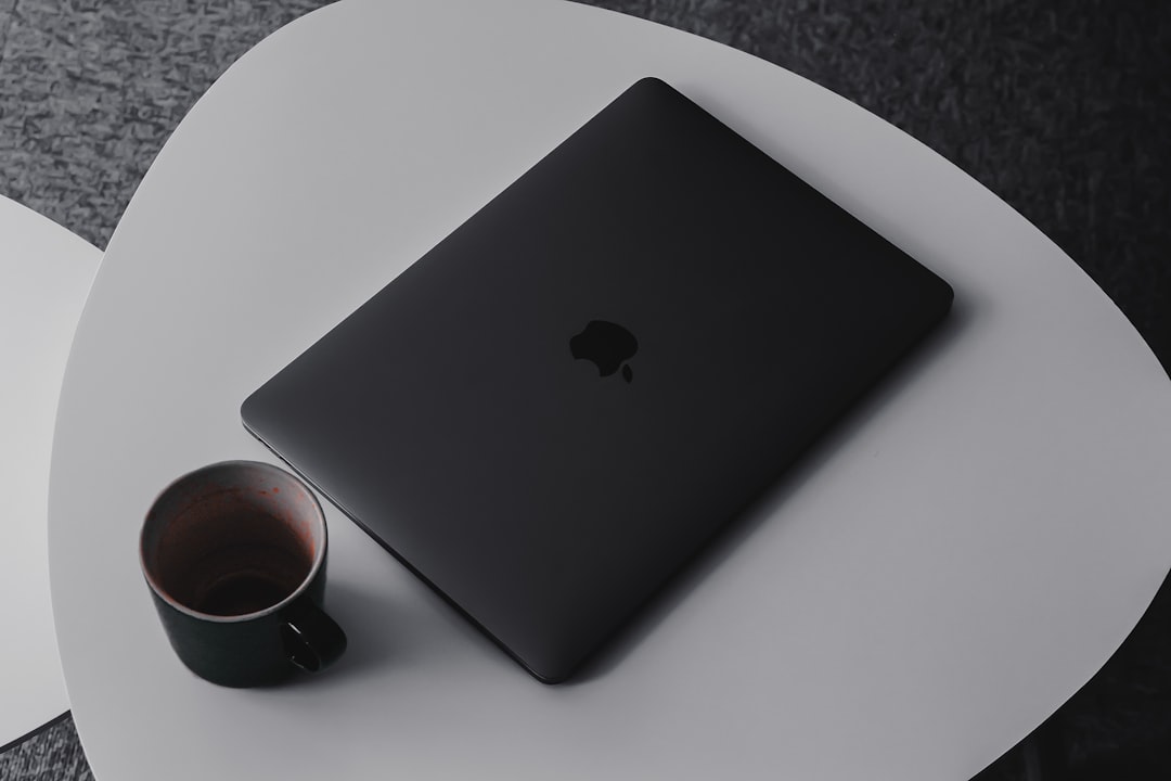 MacBook Pro beside mug on table