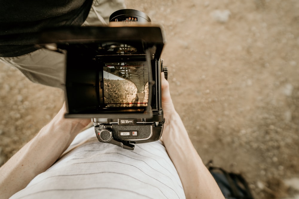 person holding camera while standing on ground