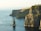 rock formation beside sea under white sky