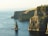 rock formation beside sea under white sky