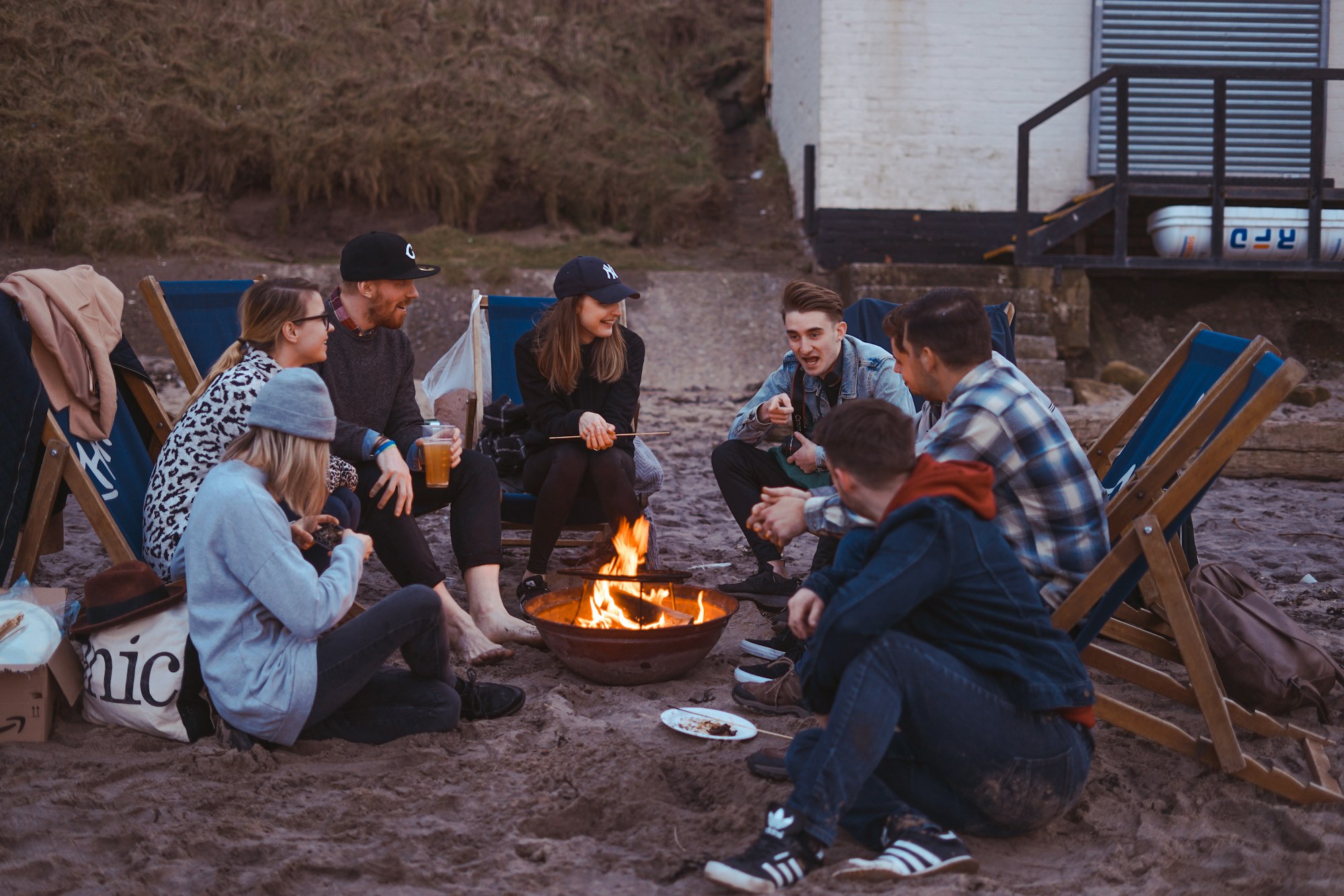 group of people sitting on front firepit on a camping trip
