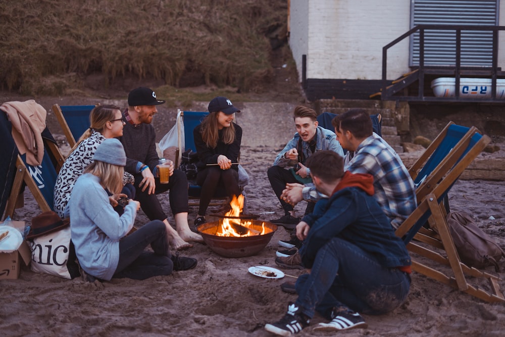 group of people sitting on front firepit