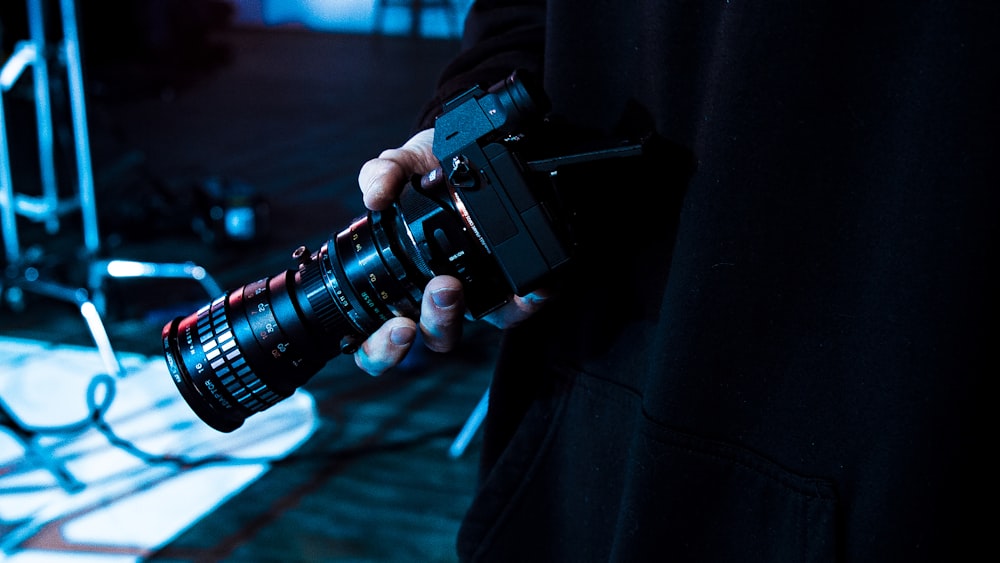 person holding black MILC camera