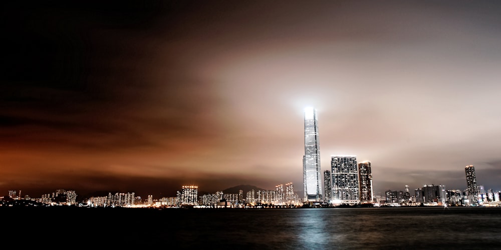 Skyline der Stadt in der Nähe eines Gewässers während der Nachttimne