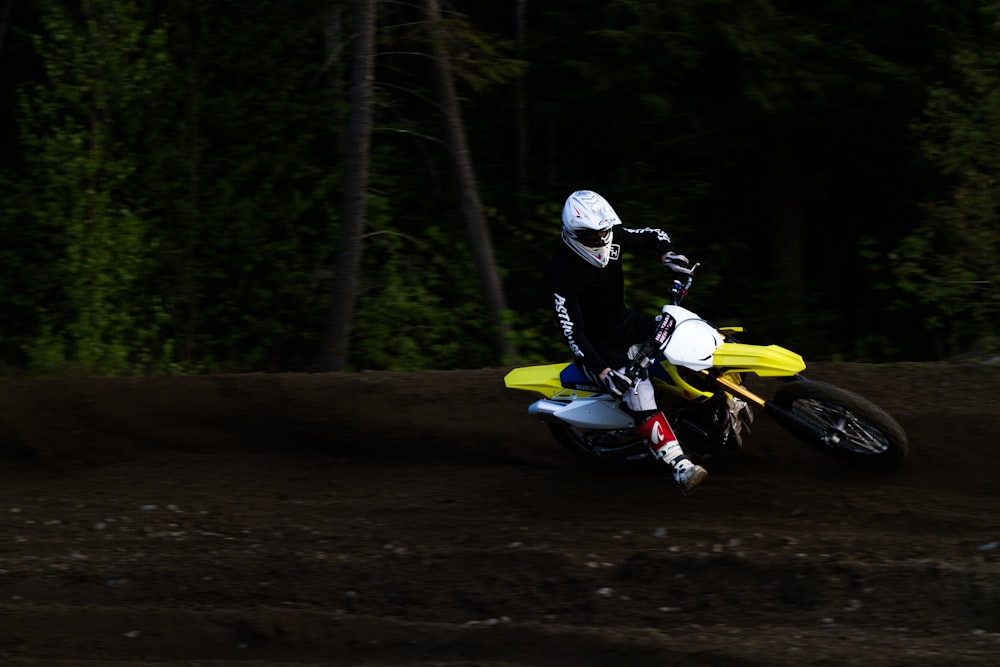 homem pilotando moto de terra amarela e branca de motocross