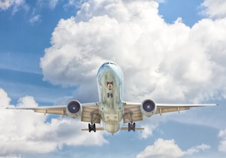 gray and white airplane on flight near clear blue sky