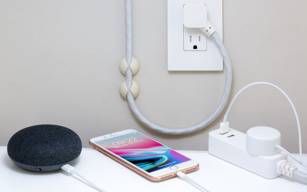 a cell phone plugged in to a wall charger