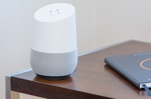 white and gray Google home on brown table