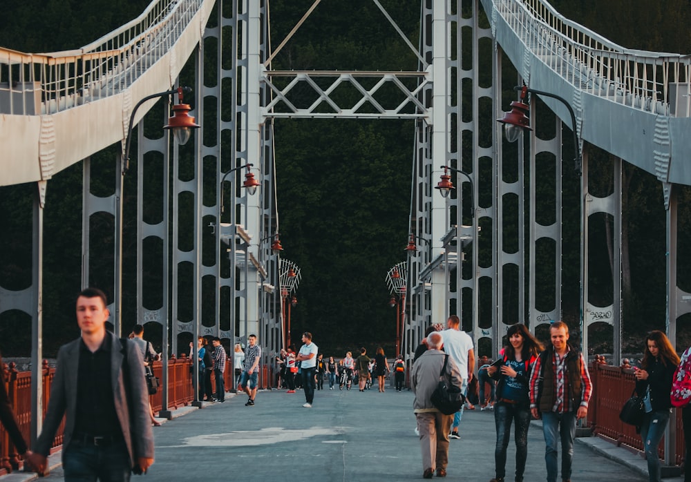 people walking and standing on bridge
