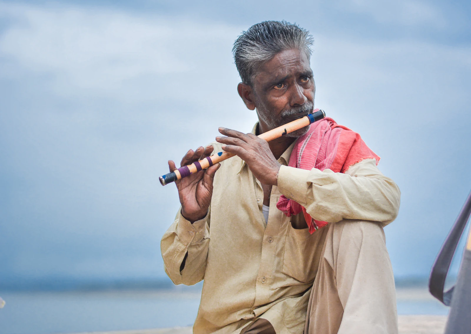 Flautist playing a bamboo flute outdoors