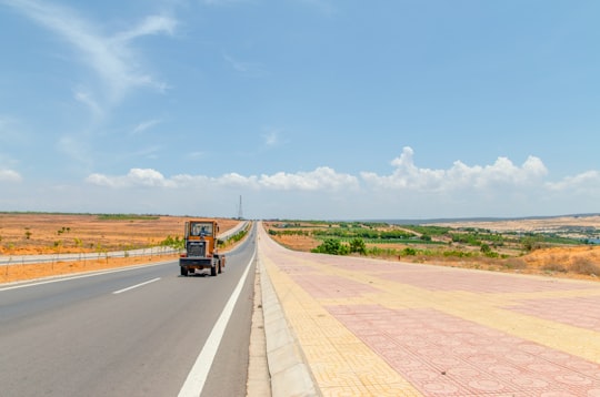 riding brown semi-truck trailer on road in Mui Ne Vietnam