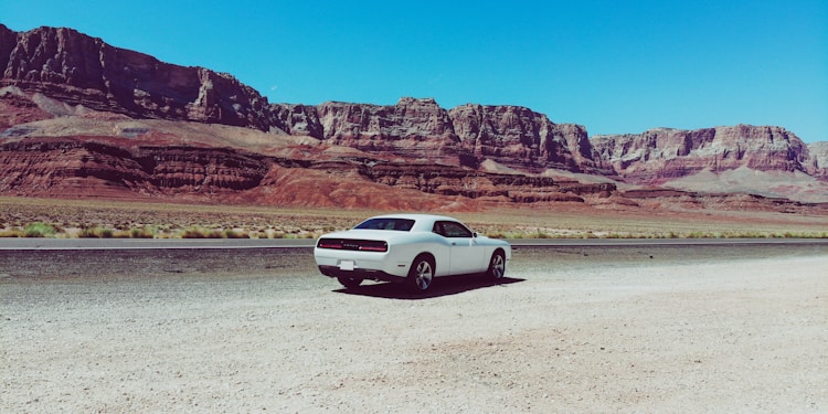 white coupe parked on desert field